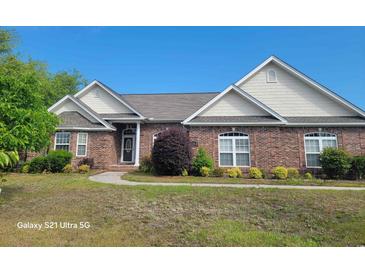 Charming brick home with lush landscaping and a well-manicured lawn at 153 Highmeadow Ln., Aynor, SC 29511