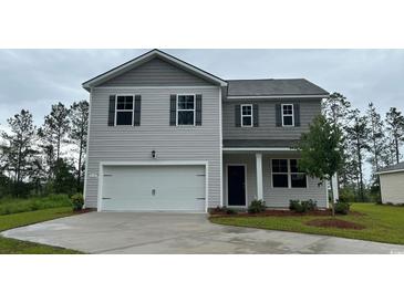 Two-story home features a two-car garage, gray siding and black shutters at 210 Bald Cypress Way, Conway, SC 29527