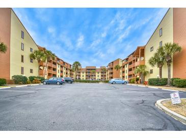 Condominium parking lot with palm trees and balconies under a sunny blue sky at 5507 N Ocean Blvd. # 304, Myrtle Beach, SC 29577