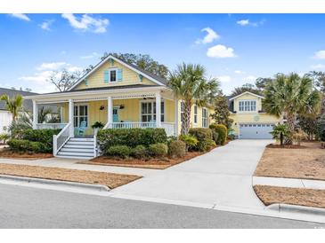 Charming yellow two-story home with a welcoming porch and manicured landscaping at 6514 Anchors Bend Dr Sw, Ocean Isle Beach, NC 28469