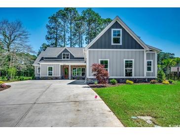 Charming two-story home with a well-manicured lawn, long driveway, and beautiful architectural details at 1007 Brood Ct., Conway, SC 29526