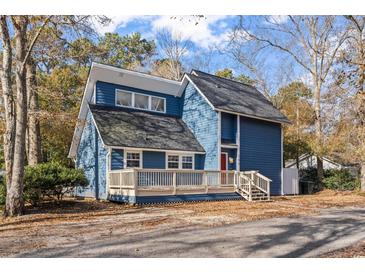 Charming two-story home with blue siding, a spacious front porch, and mature trees in a quiet neighborhood at 109 Clemson Rd., Conway, SC 29526