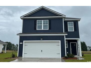 Two-story home with navy blue siding, a white garage door, and black shutters at 144 Leyland Cypress Dr, Conway, SC 29527