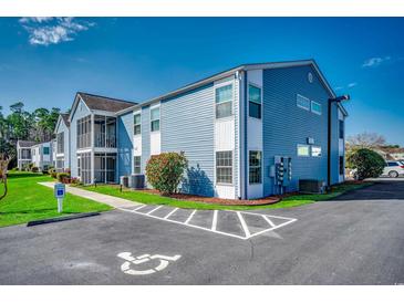 Charming two-story condo with blue siding, a screened-in porch, and reserved handicap parking at 2151 Clearwater Dr. # C, Surfside Beach, SC 29575