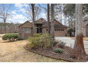 Charming brick home featuring a well-maintained front yard and an attached two-car garage at 3178 River Bluff Ln., Little River, SC 29566