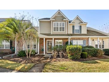 Charming two-story townhouse featuring brick accents, manicured landscaping, and inviting front porch at 677 Wilshire Ln. # 677, Murrells Inlet, SC 29576