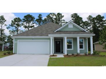 Charming one-story home featuring green siding, a gray roof, and a white garage door at 8055 Bear Claw Ct., Conway, SC 29526