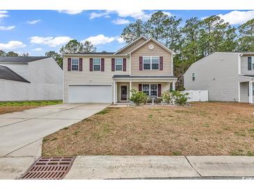 Charming two-story home featuring a well-manicured lawn, inviting front porch, and attached garage at 145 Bendick Ct., Little River, SC 29566