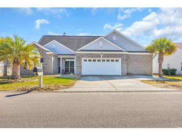 Charming single-story home features a well-manicured lawn, a two-car garage, and beautiful palm trees at 2385 Windmill Way, Myrtle Beach, SC 29579