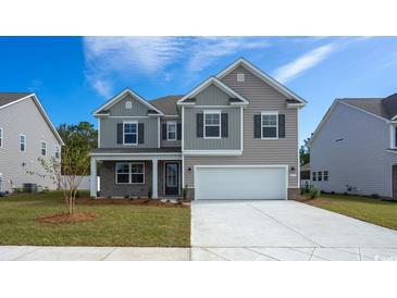 Beautiful two-story home with gray siding, shutters, and a two car garage on a clear day at 6063 Forest Dell Ct, Myrtle Beach, SC 29579