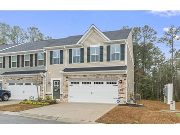 Charming townhome with a two-car garage and stone accents and green shutters at 101 Galil Dr. # A, Myrtle Beach, SC 29579