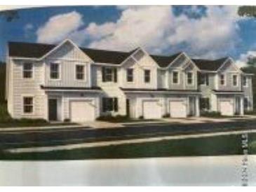 Exterior view of new townhome construction with attached garages and pleasant front yards at 1149 Windy Grove Ln Sw # 15, Ocean Isle Beach, NC 28469