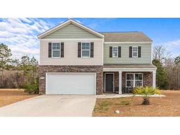 Charming two-story home boasts a two-car garage, complemented by a landscaped front yard and neutral color palette at 224 Pine Forest Dr., Conway, SC 29526