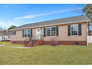 Charming single-story home featuring a classic tan exterior and a well-manicured front yard at 308 Stone Throw Dr., Murrells Inlet, SC 29576