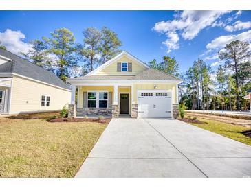 Charming single-story home featuring a sunny yellow exterior, stone accents, and a convenient attached garage at 3127 Tiger Tail Rd., Conway, SC 29526