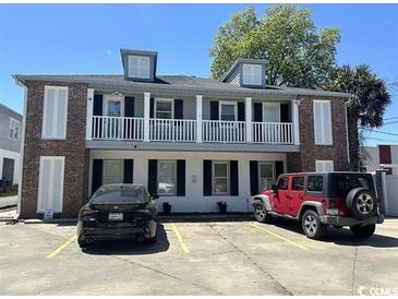 Two-story building with a black Lexus and red Jeep parked out front under a sunny blue sky at 415 28Th Ave. N # 4-A, Myrtle Beach, SC 29577