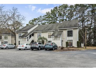 Well-maintained condo complex exterior with ample parking and mature trees, offering a comfortable and convenient living environment at 4502 Little River Inn Ln. # 2507, Little River, SC 29566
