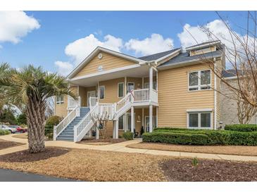 Charming condo with tan siding, white trim, and inviting front staircase at 4515 Lighthouse Dr. # 25B, Little River, SC 29566