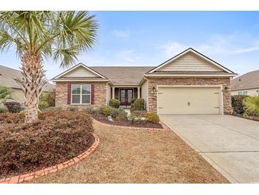 Charming home with stone accents, a manicured lawn, and a palm tree in a desirable neighborhood at 5230 Piemonte Ln., Myrtle Beach, SC 29579