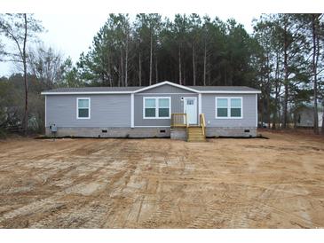 Charming single-story home with gray siding, white trim, and a neatly landscaped front yard at 5810 Hwy 9, Nichols, SC 29581