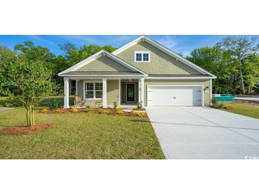 Charming single-story home with a well-manicured lawn, covered porch, and attached garage at 582 Haven View Way, Murrells Inlet, SC 29576