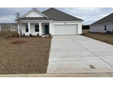 Charming single-story home features a two-car garage, manicured lawn, and a welcoming entrance, perfect for a modern lifestyle at 836 Buttonwood Dr., Conway, SC 29527