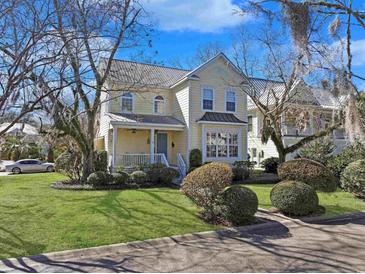 Charming two-story home with a metal roof, well-manicured lawn, and mature landscaping at 10 Orchard Ave., Murrells Inlet, SC 29576