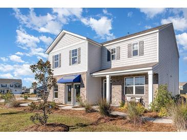 Charming two-story home featuring a mix of brick and siding under a blue sky at 124 Shucking St., Myrtle Beach, SC 29588