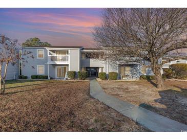 Charming two-story condo featuring a quaint balcony, manicured landscaping, and a welcoming walkway at 1356 Glenns Bay Rd. # 203K, Myrtle Beach, SC 29575