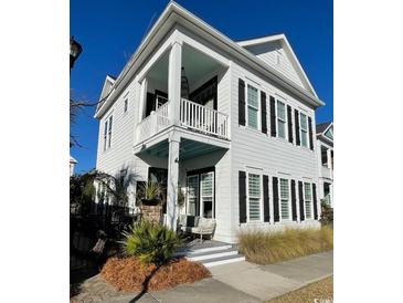 Charming two-story home boasts white siding, black shutters, and a welcoming porch in a well-kept community at 1391 Peterson St., Myrtle Beach, SC 29577