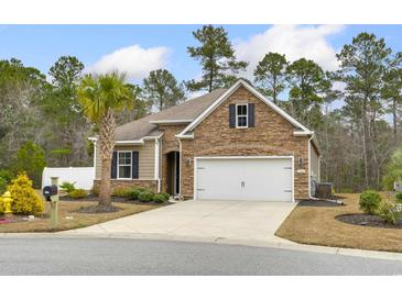 Charming one-story home showcasing a stone facade, attached garage, and a well-manicured front lawn with a palm tree at 1442 Chanson Ct., Little River, SC 29566