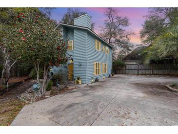 Charming two-story home featuring light blue siding, yellow shutters, and a paved driveway at 2270 Vereen Circle, Little River, SC 29566