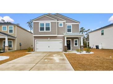 Charming two-story home with a well-manicured lawn, light brown siding, and a two-car garage at 242 Timber Oaks Dr., Myrtle Beach, SC 29588