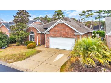 Charming brick home featuring a two-car garage and a well-manicured lawn at 3791 Cagney Ln., Myrtle Beach, SC 29577