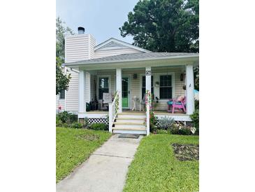 Charming home featuring a cozy front porch with colorful decor and well-maintained landscaping at 4115 Little River Rd., Myrtle Beach, SC 29577