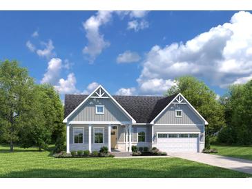 Charming single-story home featuring a covered porch, two-car garage, and beautifully landscaped front yard at 7023 Denim Loop, Myrtle Beach, SC 29579