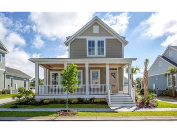 Charming two-story home featuring a welcoming front porch with white columns and manicured landscaping at 8156 Living Tide Dr., Myrtle Beach, SC 29572