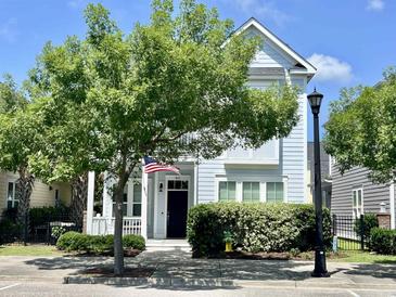 Charming two-story home with a well-manicured lawn and inviting front porch with an American flag at 843 Howard Ave., Myrtle Beach, SC 29577