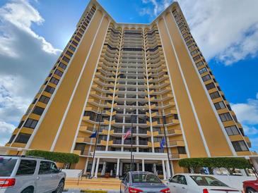 A low-angle view of a high-rise condo building, showcasing its balconies and modern architecture under a blue sky at 9650 Shore Dr. # 706, Myrtle Beach, SC 29572