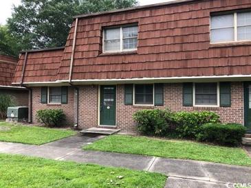 Charming brick townhouse with a wood roof, green door, and manicured landscaping at 1025 Carolina Rd. # L-1, Conway, SC 29526