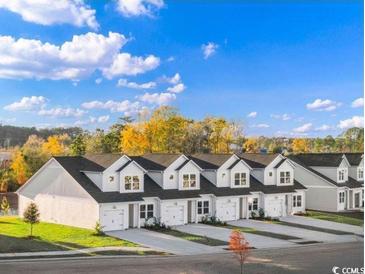 Newly constructed townhomes feature attached garages and modern farmhouse design on a sunny day at 1150 Blueback Herring Way # 145, Conway, SC 29526