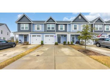 Charming townhomes with individual garages and manicured lawns offer appealing curb appeal at 145 Goldenrod Circle # 7B, Little River, SC 29566