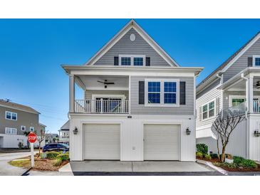 Charming two-story home with gray siding, white trim, and a two-car garage offers timeless curb appeal at 223 Gloucester Way, Little River, SC 29566