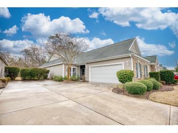 Charming single-story home with attached garage, well-maintained landscaping, and a spacious concrete driveway at 440 Woodpecker Ln. # A, Murrells Inlet, SC 29576