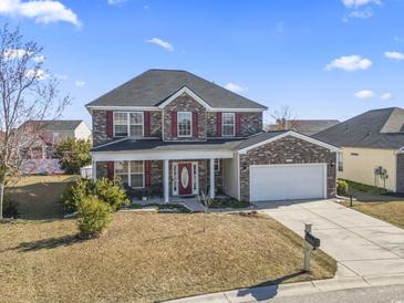 Charming two-story brick home with a well-manicured lawn, attached garage, and inviting front porch at 445 Mooreland Dr., Myrtle Beach, SC 29588