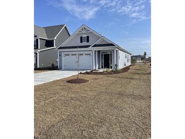 Charming single-story home with a two-car garage, landscaped yard, and classic architectural details at 627 Castle Ct., Myrtle Beach, SC 29579