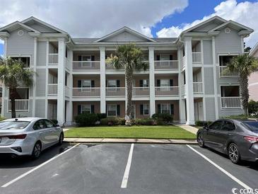 Condo building featuring multiple units and balconies, lush landscaping, and convenient parking spaces at 637 Waterway Village Blvd. # 13-E, Myrtle Beach, SC 29579