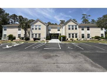 Spacious condo building exterior with ample parking and sidewalk entrance at 8545 Hopkins Circle # G, Myrtle Beach, SC 29575
