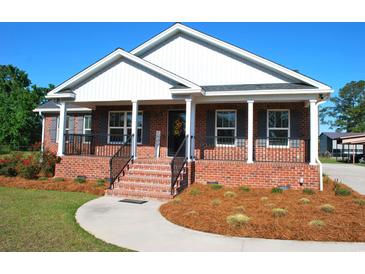 Charming brick home with a inviting front porch, landscaped yard, and black shutters at 960 South Farr Ave., Andrews, SC 29510