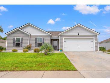 Charming single-story home with well-manicured lawn, gray siding and a two car garage at 1109 Donald St., Conway, SC 29527